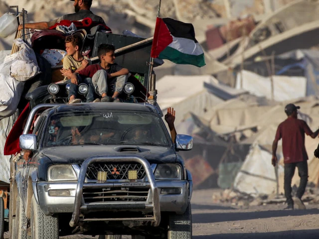 a palestinian flag flies from a truck carrying people and children with their belongings as people evacuate southbound from gaza city on september 2 2025 photo afp