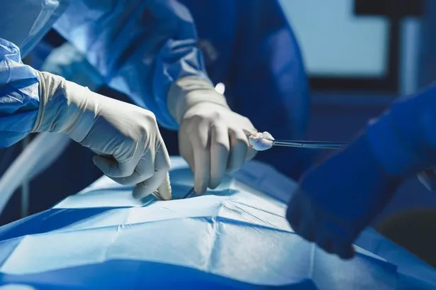 Close-up of surgeon with nurse and and assistant during operation in operating room.