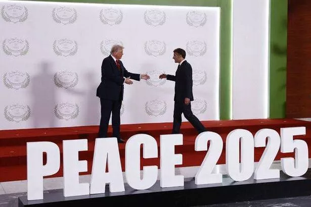 French President Emmanuel Macron (R) arrives to meet US President Donald Trump (R) during the greetings ceremony at the Gaza Pea