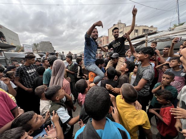 KHAN YUNIS, GAZA - OCTOBER 09: Palestinians gathered in the city of Khan Yunis are celebrating after the announcement of the ceasefire agreement in Gaza on October 09, 2025 in Khan Yunis, Gaza. A ceasefire agreement between Israel and Hamas came into effect in the Gaza Strip on Thursday following marathon mediation efforts to end a two-year deadly war in the Palestinian enclave. Israel
