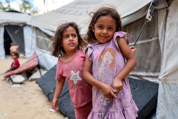 Girls outside a tent for displaced peope at the Qatari-built and now-damaged Hamad City complex in the southern Gaza Strip