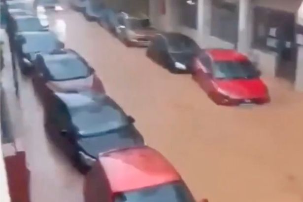 Cars submerged in muddy flood water in Ibiza