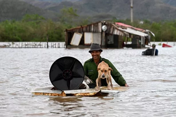 A farmer rescues his dog and some belongings in Cuba