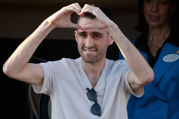 TOPSHOT - Released Israeli hostage Avinatan Or greets well-wishers upon arriving at Beilinson Hospital in the Rabin Medical Centre in Petah Tikva in central Israel on October 13, 2025. Israel said that the last 20 living hostages released by Hamas on October 13, had arrived in the country. (Photo by Menahem Kahana / AFP) (Photo by MENAHEM KAHANA/AFP via Getty Images)