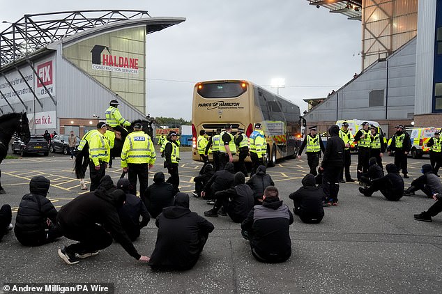 Rangers fans block the team bus with a sitdown protest after their team