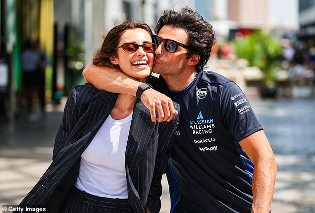 Carlos Sainz gives a kiss to his girlfriend, Rebecca Donaldson, during the Saudi Arabia Grand Prix... but the Spaniard is unhappy at how much attention the WAGs get when the action is on