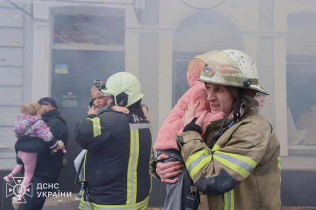Fire officials carry children from a burning nursery
