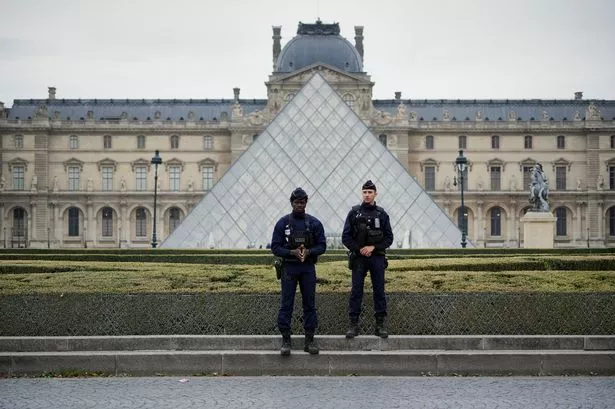 Police stand guard outside the Louvre museum