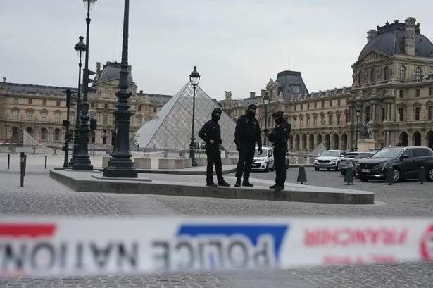 French police officers patrol in front of the Louvre Museum after it was robbed,