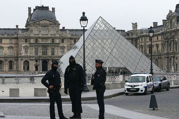 French police officers stand in front of the Louvre after today