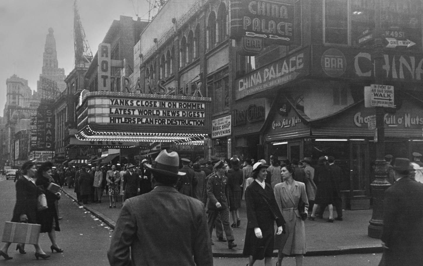 Pedestrians walk beneath the marquee of a Trans-Lux Theatre, during the Second World War, in Times Square, Midtown Manhattan, New York City, Manhattan, New York City, New York, circa 1943.