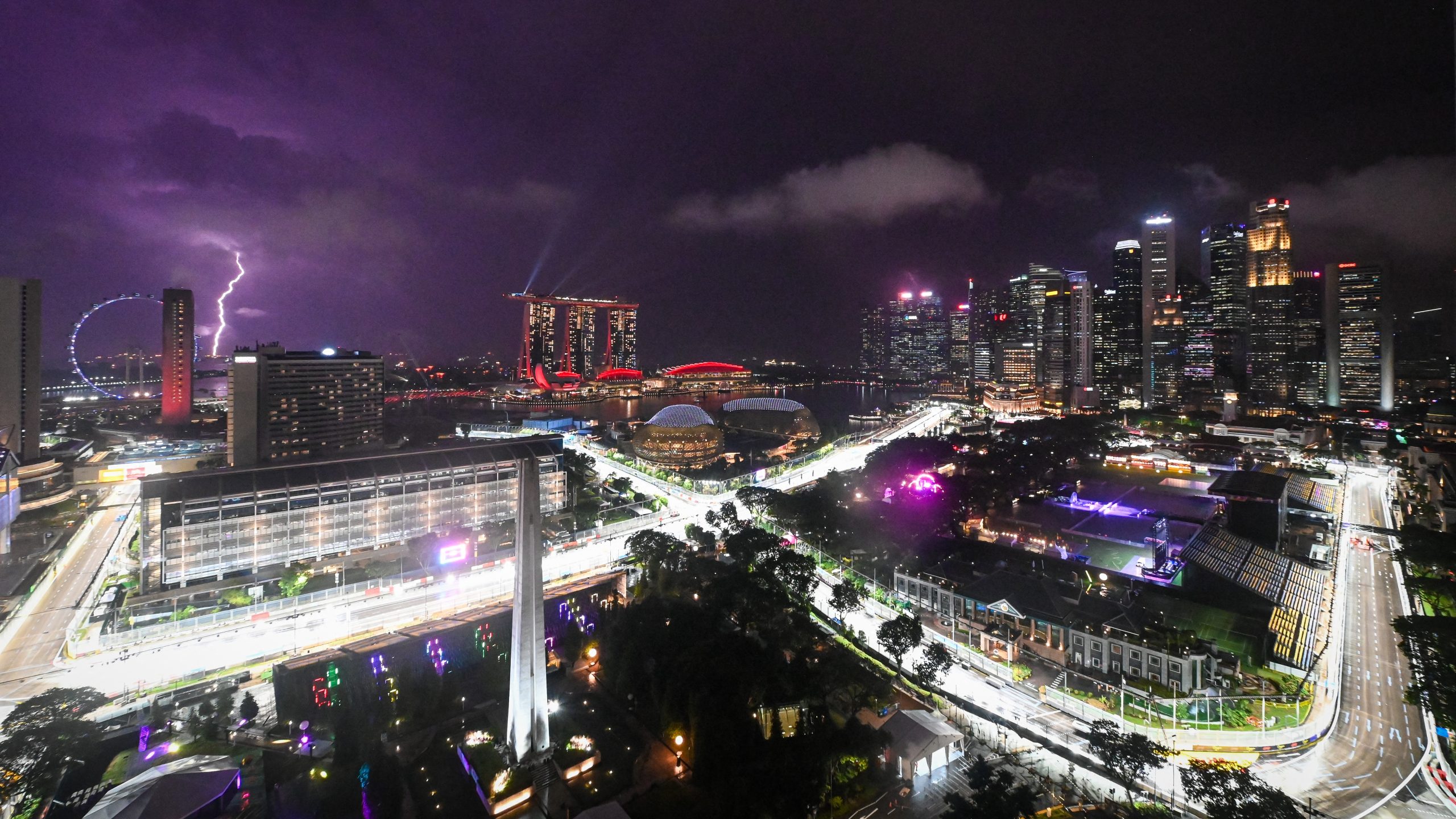 This photo shows the road circuit illuminated for the the upcoming Formula One Singapore Grand Prix at the Marina Bay Street Circuit as a lightning bolt (L) illuminates the sky in Singapore on October 1, 2025.