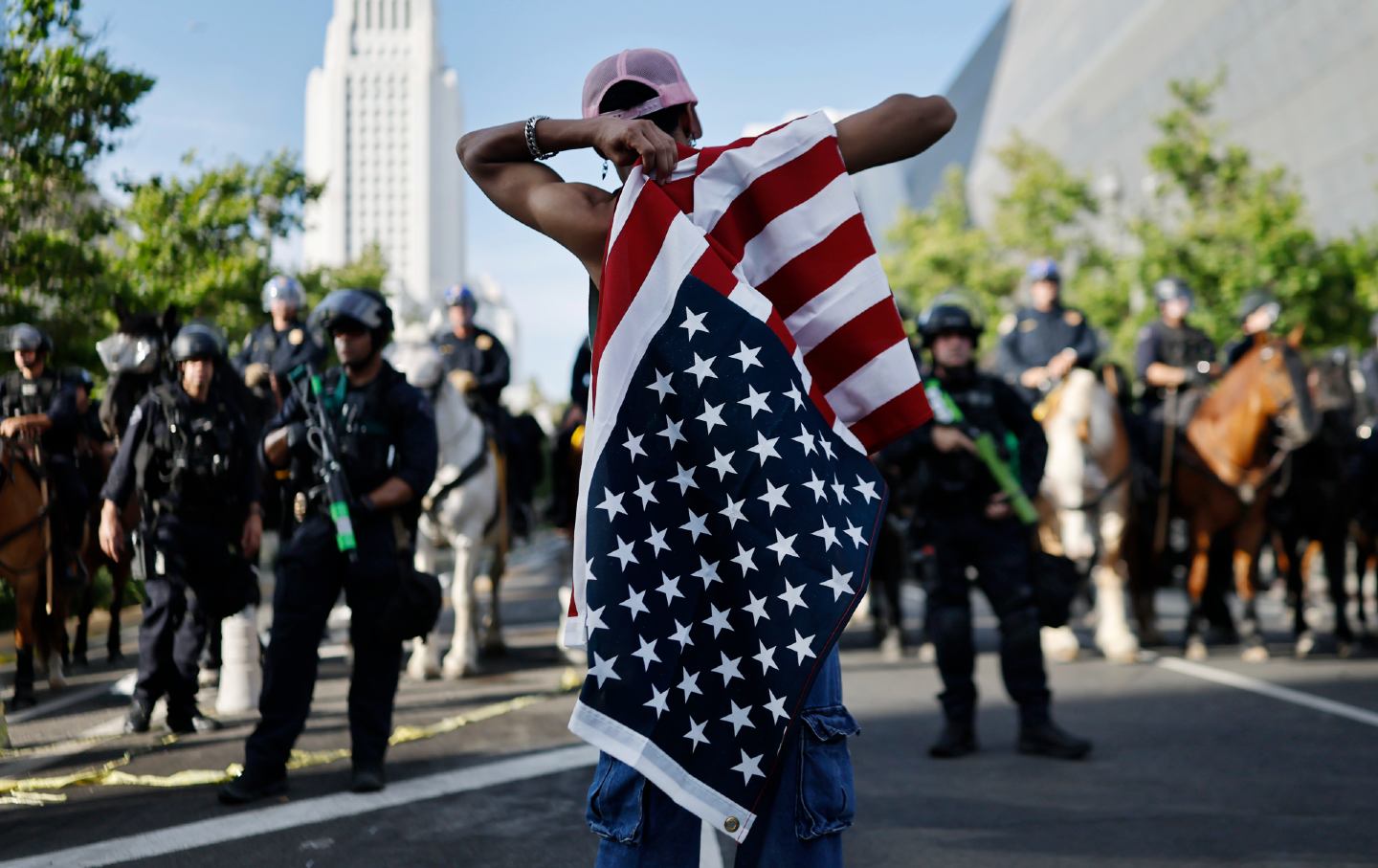Protestor holds American flag while confronting police