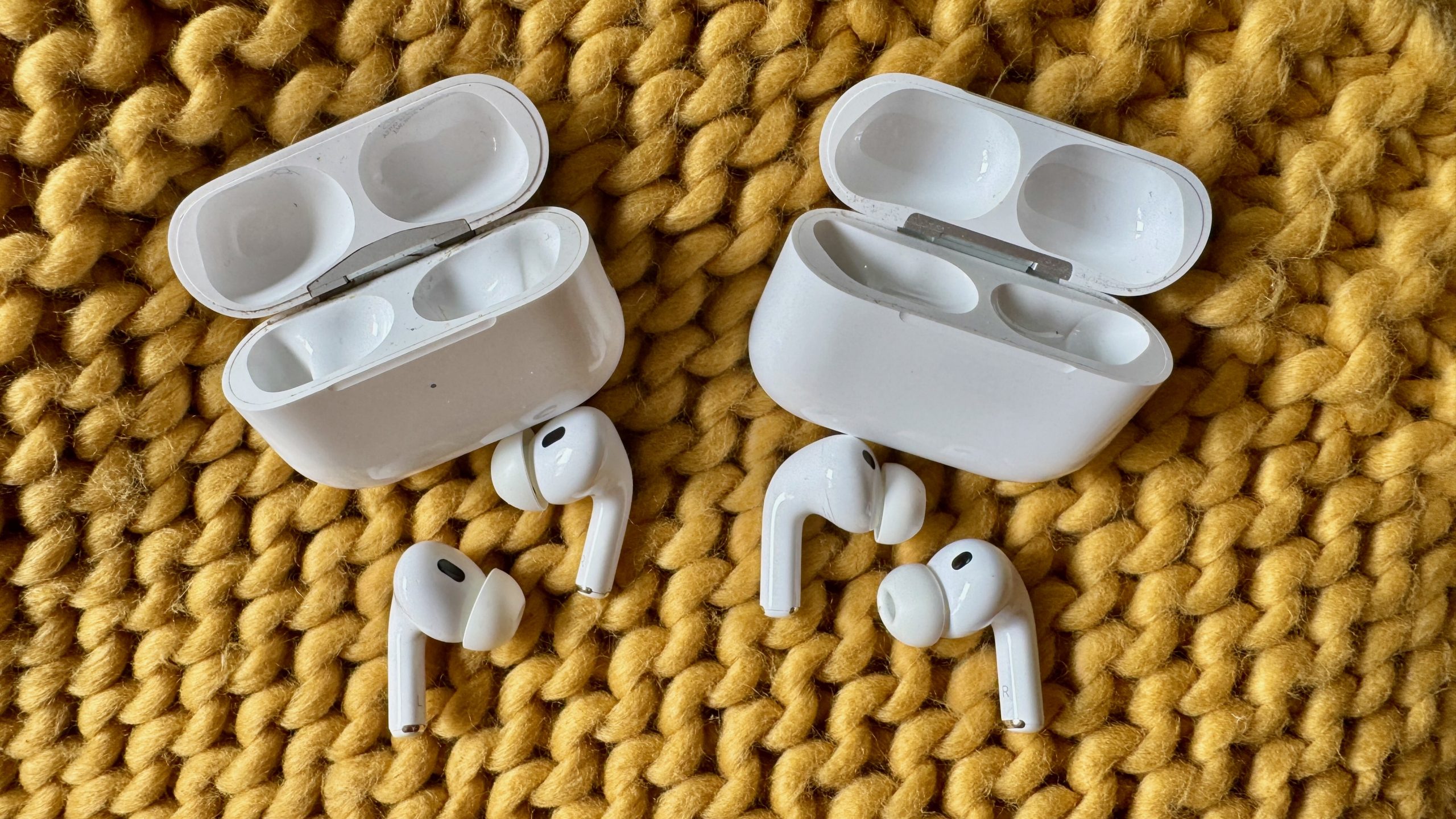AirPods Pro 3 and AirPods Pro 2 side-by-side on a knitted yellow throw.