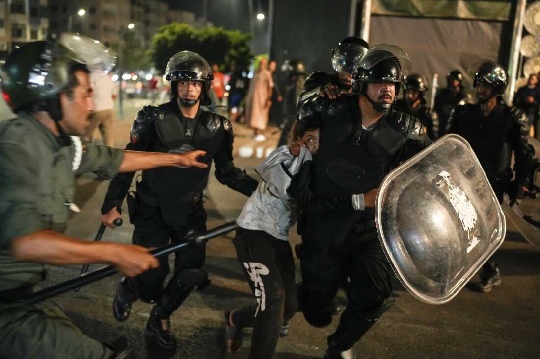 A boy is detained as youth led protests calling for healthcare and education reforms turned violent, in Sale, Morocco, on Wednesday.