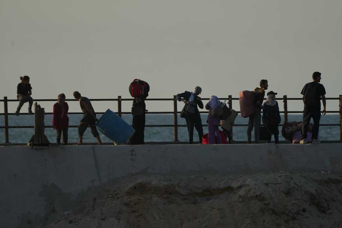 Displaced Palestinians flee northern Gaza carrying their belongings along the coastal road near Wadi Gaza, Thursday, Oct. 2, 2025.