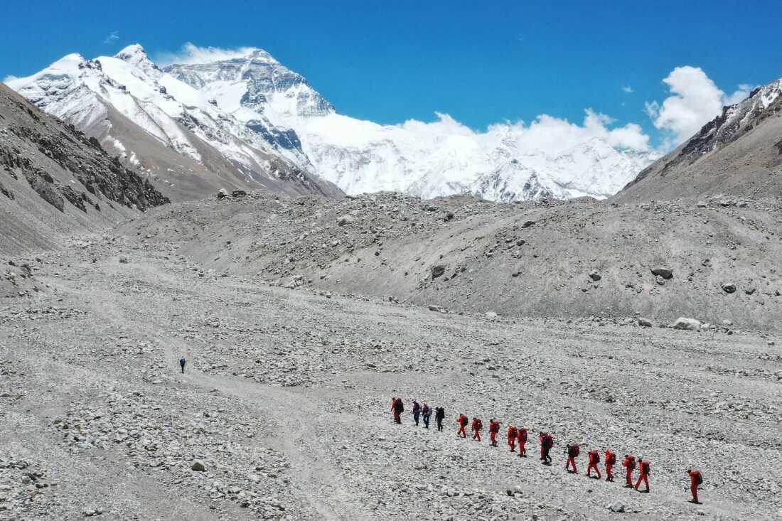 FILE - In this May 16, 2020 aerial photo released by Xinhua News Agency, Chinese surveyors hike toward a higher spot from the base camp on Mount Qomolangma at an altitude of 5,200 meters.