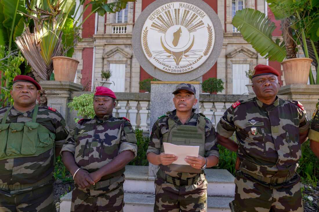 CAPSAT military unit commander Col. Michael Randrianirina, center, reads a statement saying that the armed forces are taking control of the country from the steps of the Presidency in Antananarivo, Madagascar, Tuesday, Oct. 14, 2025.