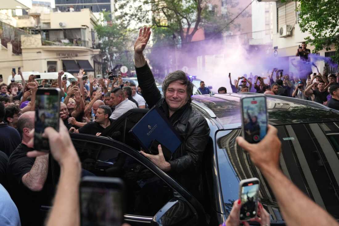 Argentine President Javier Milei waves to supporters upon arriving at a hotel in Rosario, Argentina, Thursday.