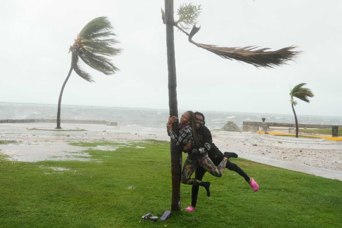 A couple jokes around Tuesday on the coast in Kingston, Jamaica, as Hurricane Melissa approaches