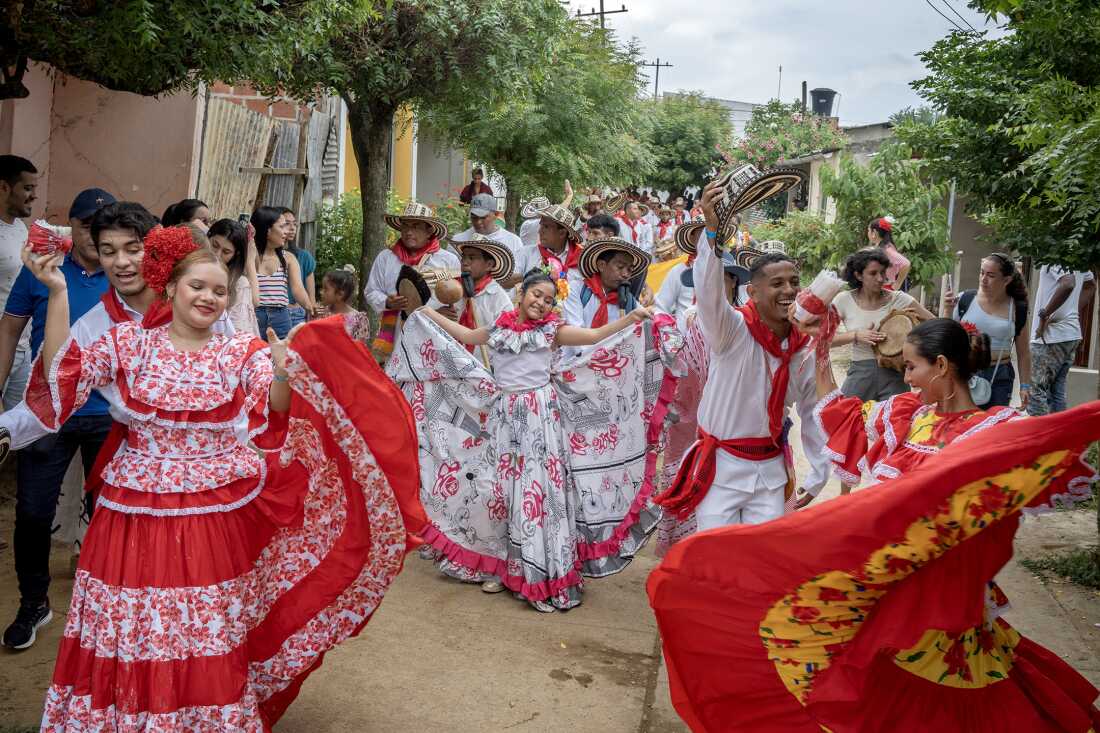 Grupos gaiteros, bailarines y público en general, desfilan hacia el cementerio de San Jacinto, Colombia, el 14 de agosto de 2022.