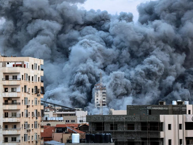 a plume of smoke rises above buildings in gaza city on october 7 2023 during an israeli air strike that hit the palestine tower building on the eve of the second anniversary of the october 7 2023 hamas attack that sparked the war delegations from hamas israel and the united states were due to convene in egypt for talks urged by us president donald trump to end the conflict photo afp
