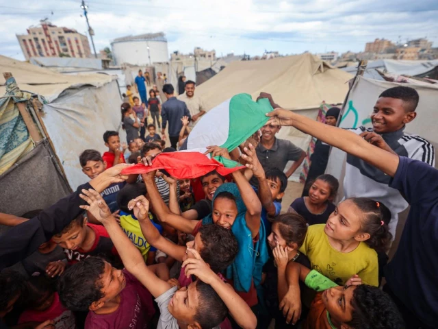 palestinian children celebrate at a camp for displaced people in nuseirat in the central gaza strip on october 9 2025 following news of a new gaza ceasefire deal israel and hamas on october 9 agreed a gaza ceasefire deal to free the remaining living hostages in a major step towards ending a war that has killed tens of thousands of people and unleashed a humanitarian catastrophe photo afp