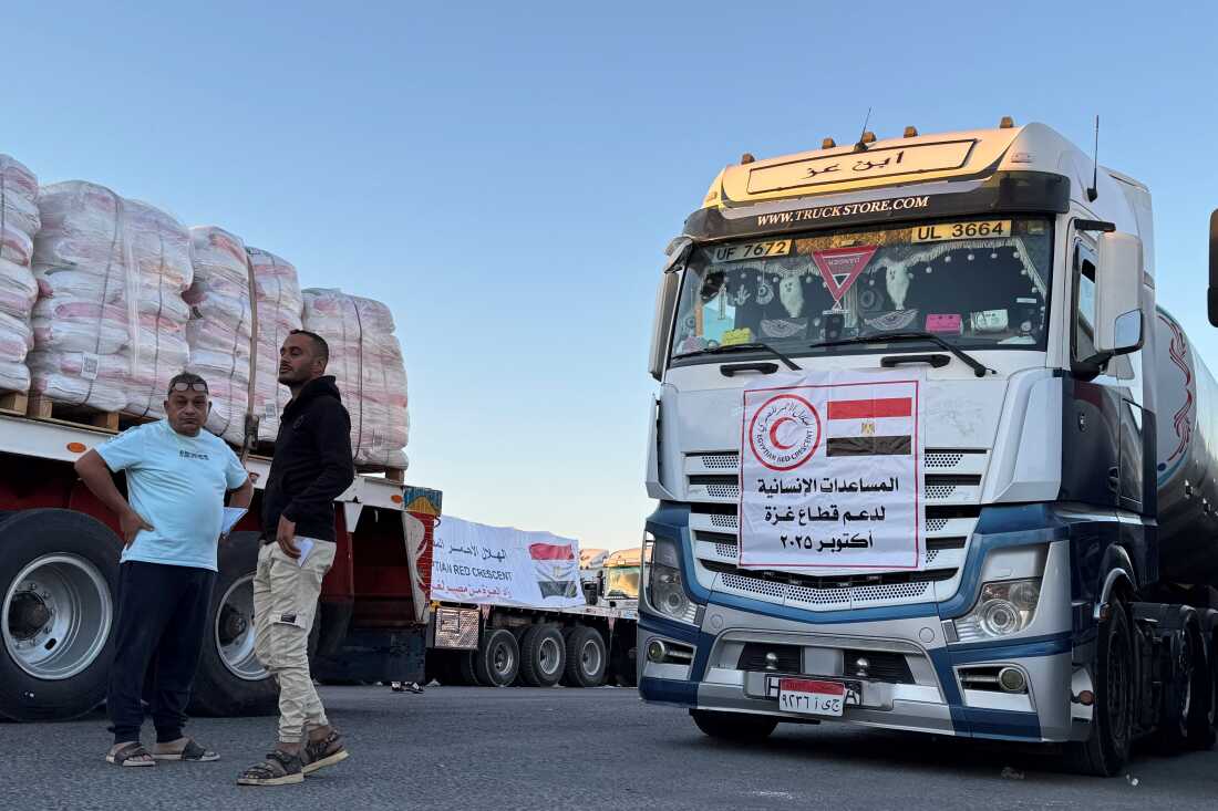 Trucks loaded with humanitarian aid on the Egyptian side of the Rafah crossing wait to cross into the Gaza Strip early on Oct. 15, 2025.