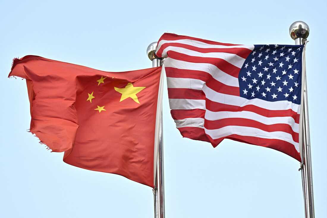 Chinese and U.S. flags wave outside a technology company in Beijing, on April 17.