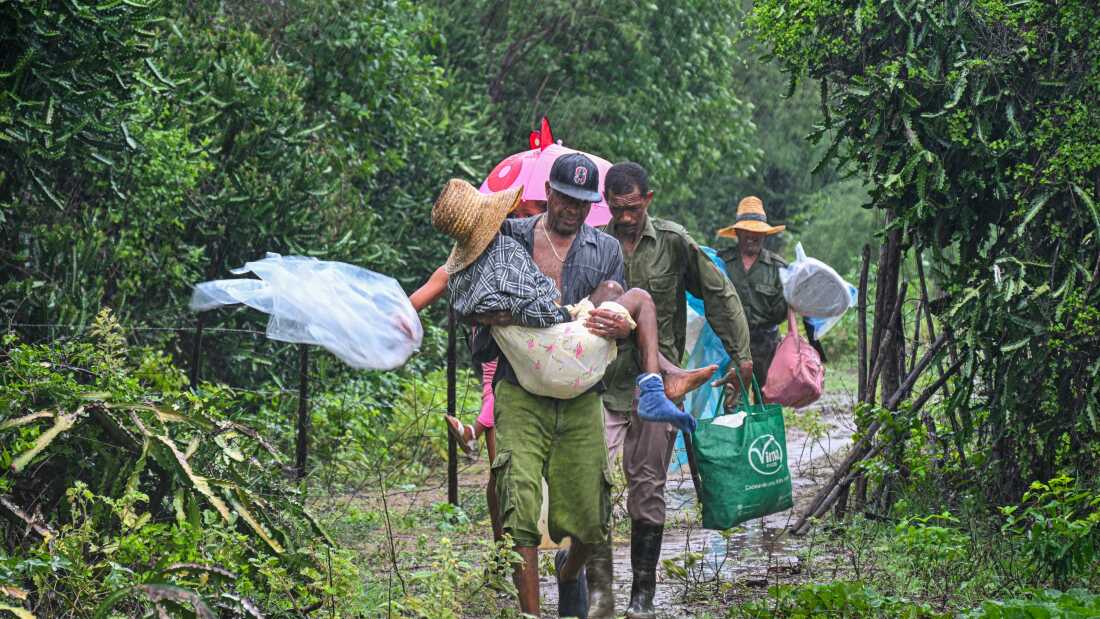 Residents can be seen walking through a pathway lined with trees as they self-evacuate under pouring rain from Playa Siboney to safe locations ahead of the arrival of Hurricane Melissa, in Santiago de Cuba, Cuba, on Oct. 28.