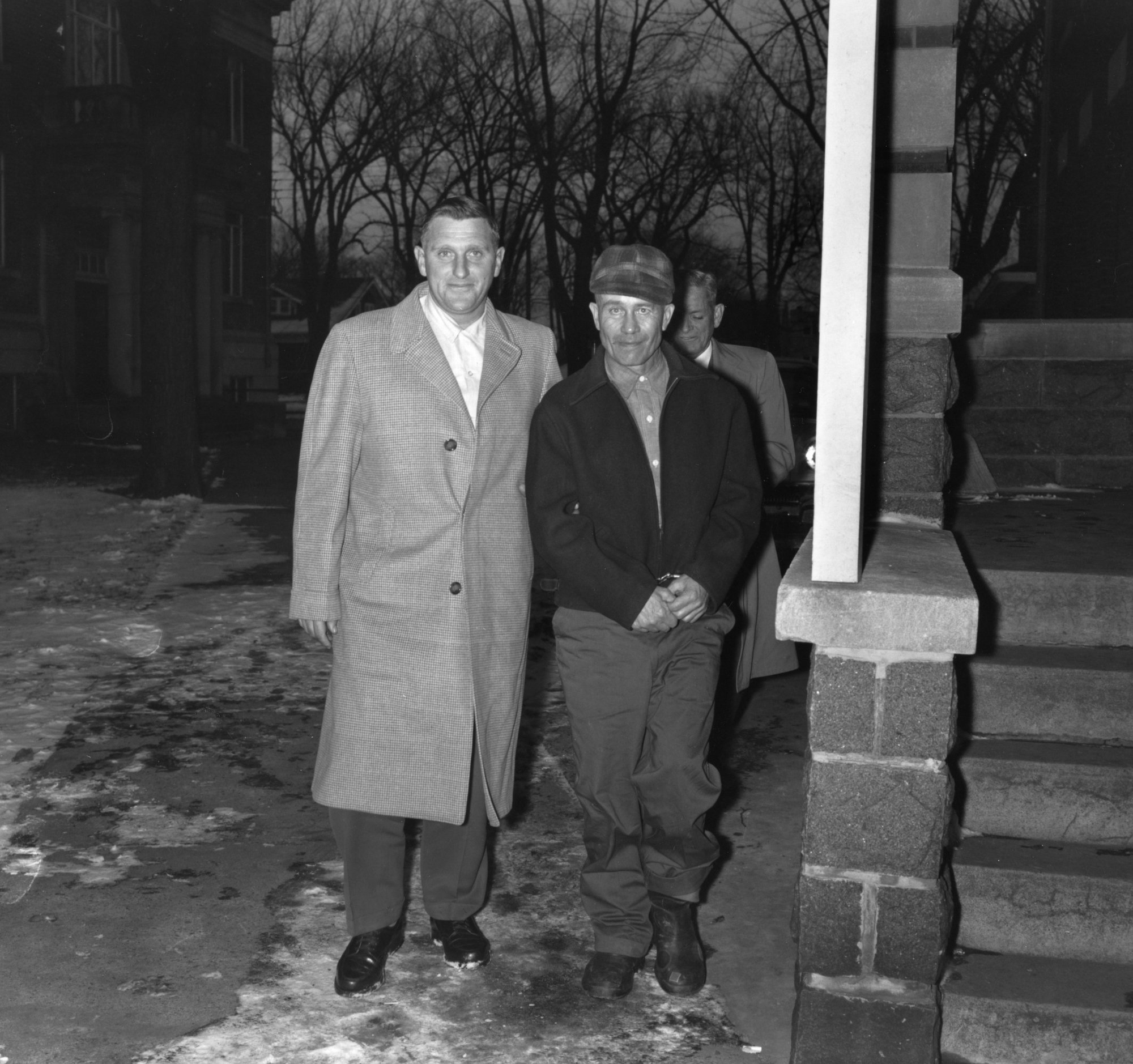Farmer Ed Gein, 51, (R), confessed slayer of two women, stands with his attorney William Belter at the Wabsara County Court.