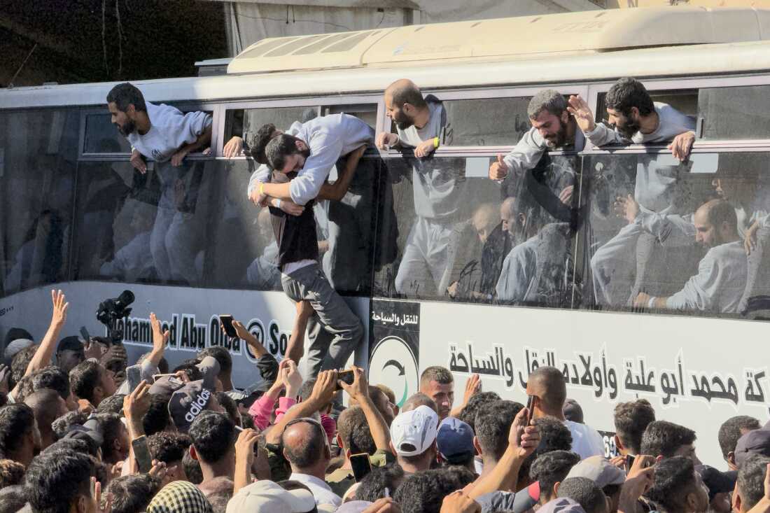 A bus carrying Palestinians released from Israeli prisons is greeted by a crowd outside the Nasser hospital in Khan Younis, Gaza Strip, on Monday.