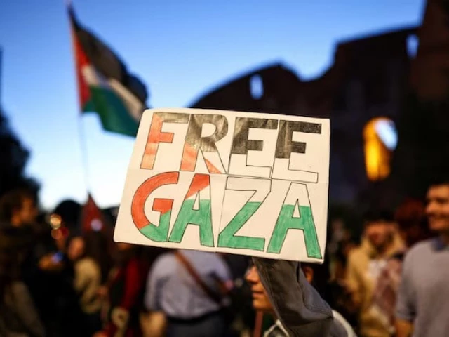 a pro palestinian protester holds a banner reading free gaza in front of the colosseum during a protest to stand in solidarity with people of gaza in rome photo reuters