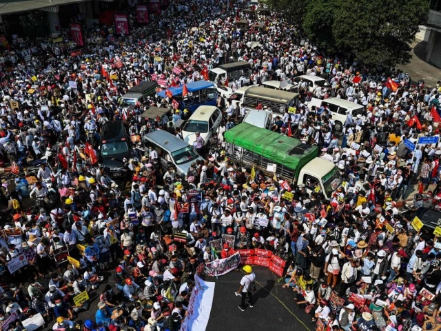 protesters mass around vehicles as they block roads during a demonstration against the military coup in yangon on feb 22 2021 photo afp