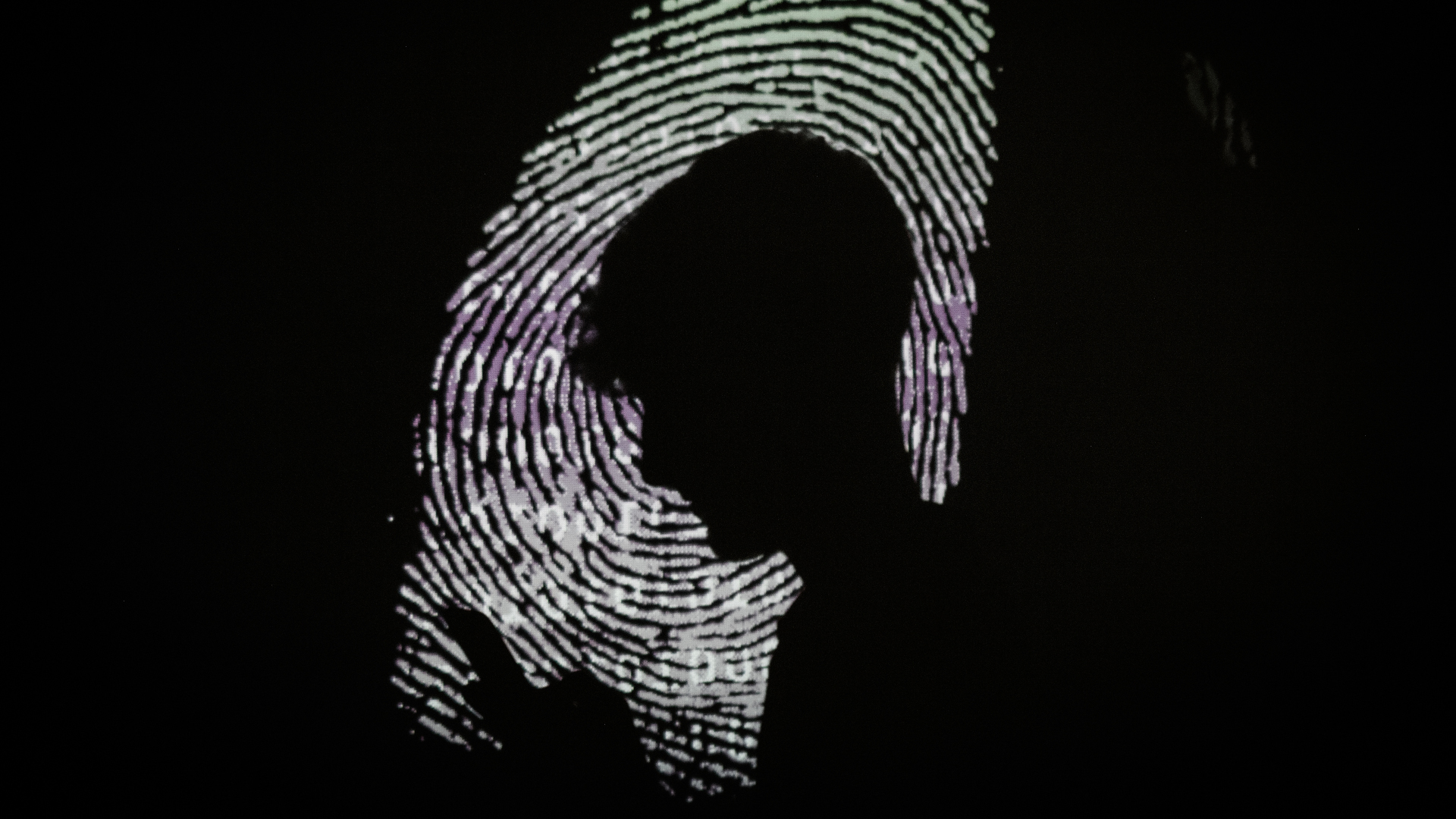 A silhouette of a boy looking at his phone on a enlarged thumbprint background