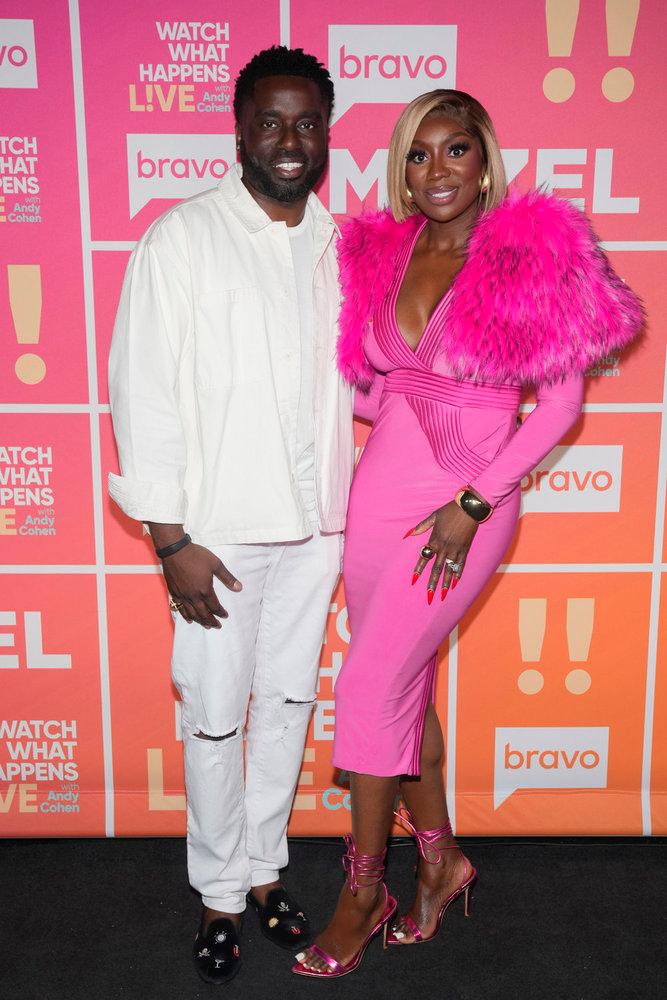 Wendy Osefo and her husband posing on the red carpet.